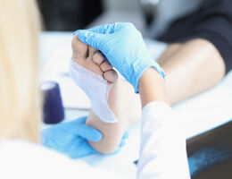  A doctor examines a patient's bandaged foot