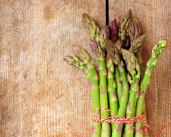 A bunch of asparagus tied with red and white string.